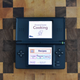 Nintendo DS open to home screen on a cutting board